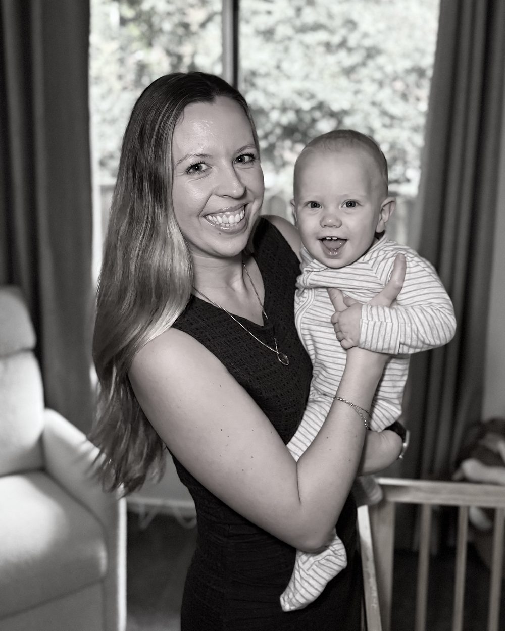 Malina, founder of Lullaby Lane Sleep Consulting, smiling and holding her son Hugo